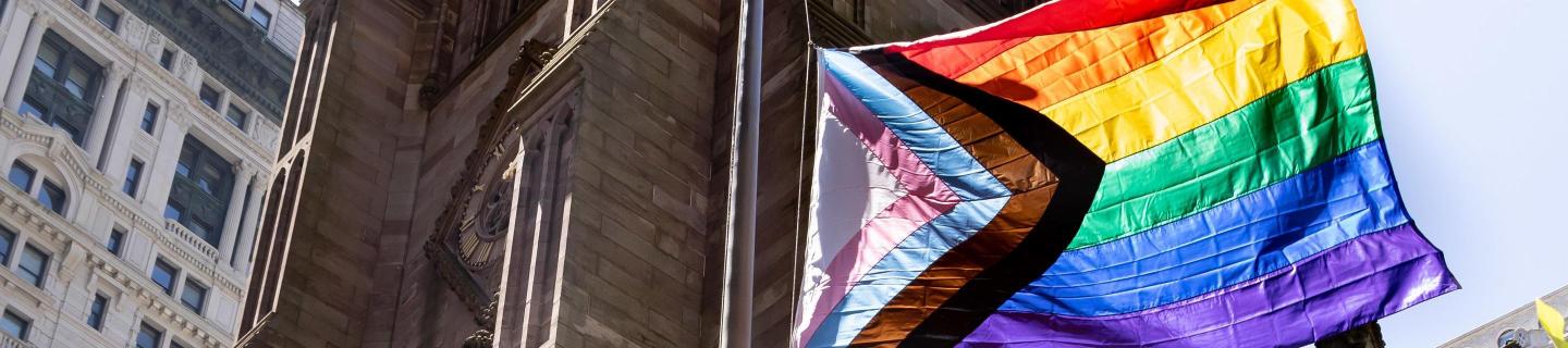 Progress Pride Flag flies next to Trinity Church